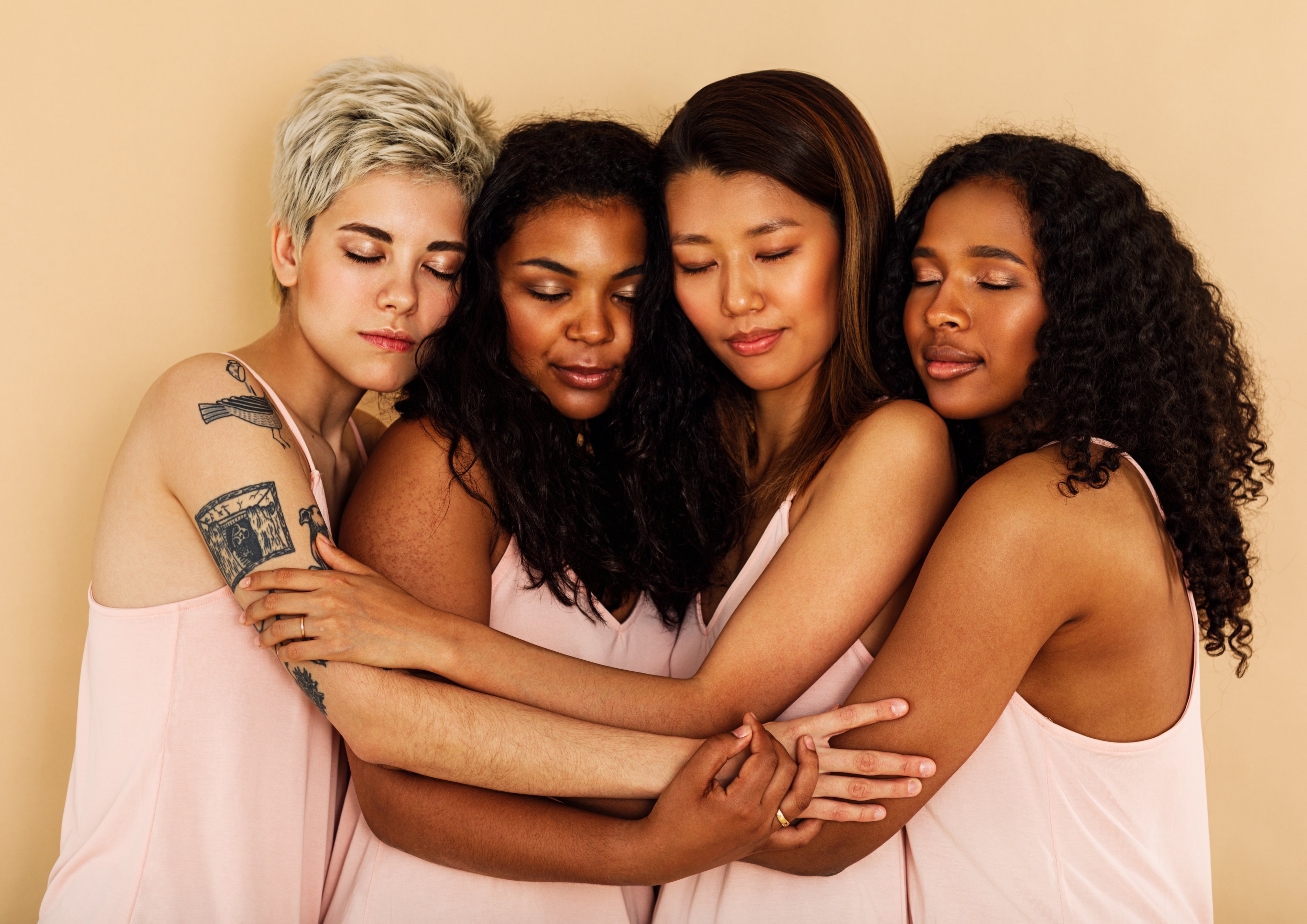 Diverse group of women in casuals standing together with eyes closed